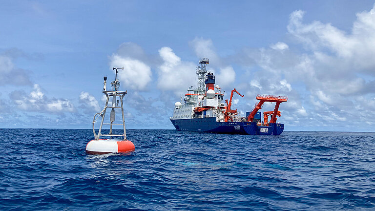 A measuring buoy and a research vessel at sea