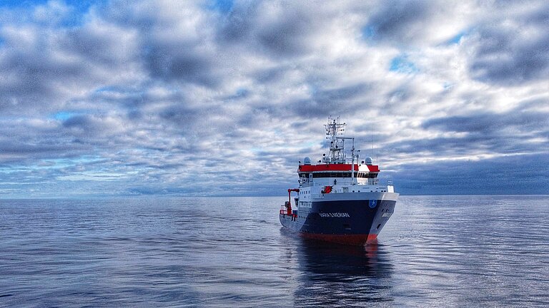 Ein Forschungsschiff auf spiegelglatter blauer See
