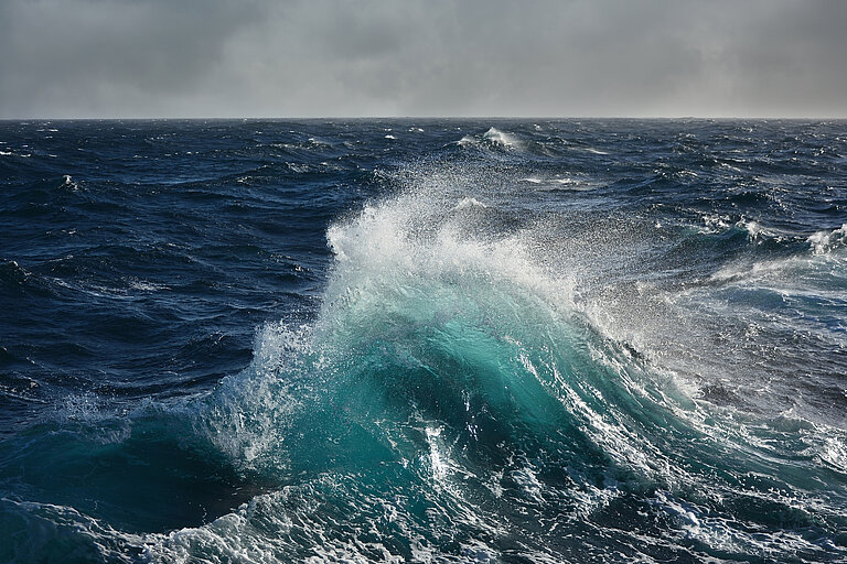 A wave breaks on the sea in stormy weather