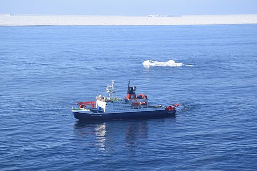 Luftaufnahme des Forschungsschiffs Polarstern mit Eisbergen im Hintergrund