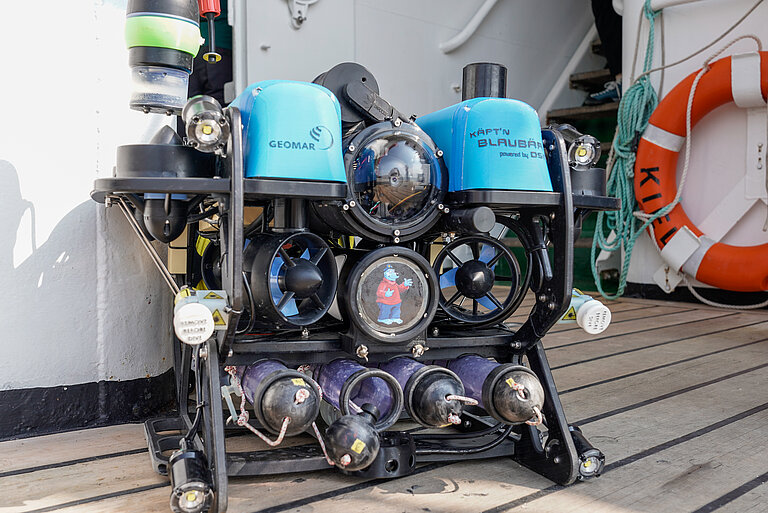 Ein wissenschaftliches Gerät mit zwei blauen Glocken steht an Bord eines Schiffes